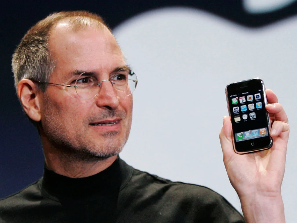 Когда появились первые айфоны. Стив Джобс айфон 1. Стив Джобс с айфоном. Стив Джобс презентация iphone 1. Стив Джобс айфон 2g.